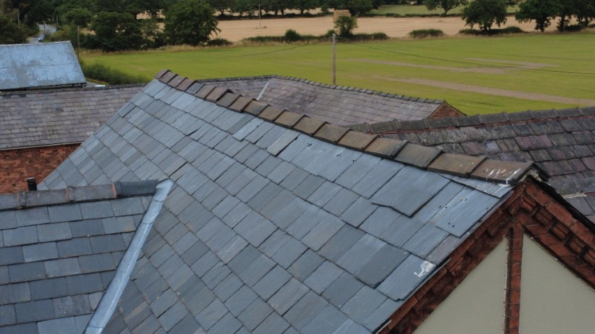 Central ridgeline deflecting heavily downwards, with poor installation of a newly-laid slate roof.