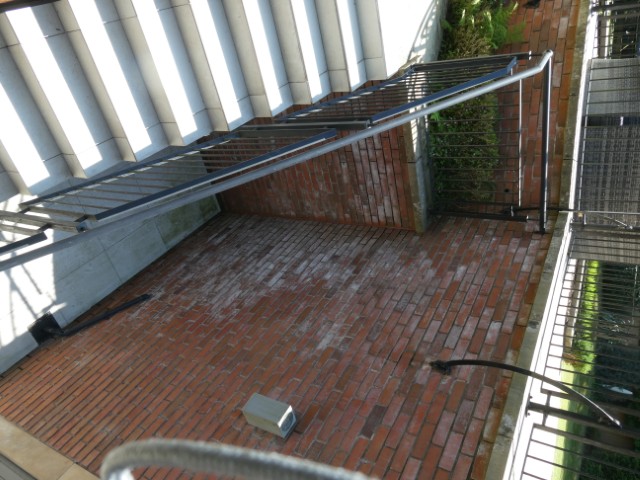 Significant efflorescence and saturation to a recessed external wall, associated with poor external drainage and ground detailing.