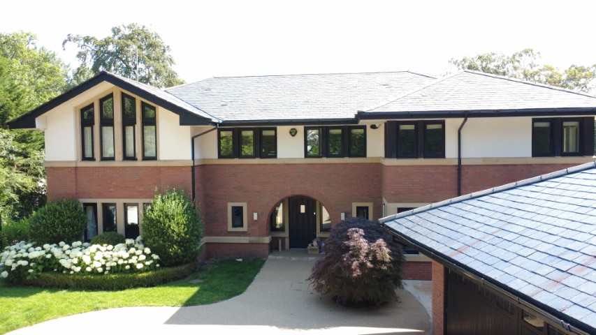 A large detached property with extensive grounds and a swimming pool.