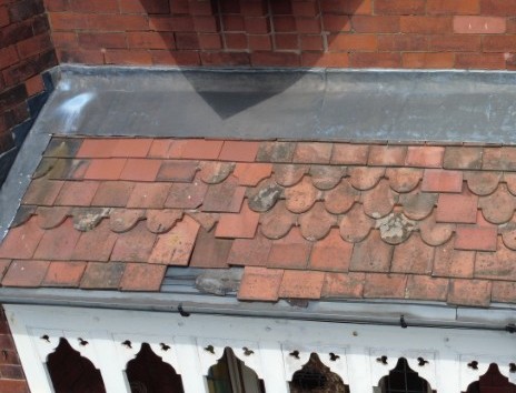 Rosemary tiled canopy roof approaching the end of its serviceable life, with localised tile defects.