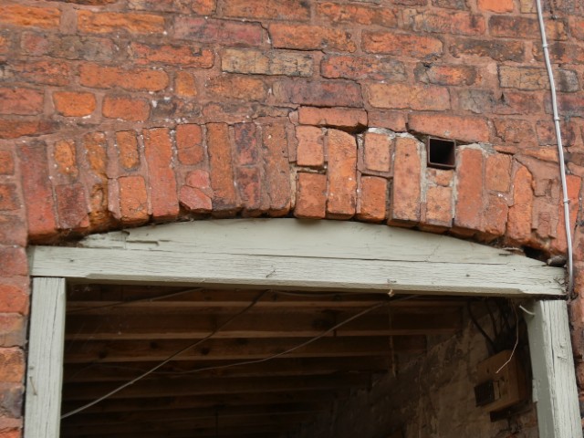 Significant structural failure of brickwork above an opening, where the masonry above is no longer being properly supported.